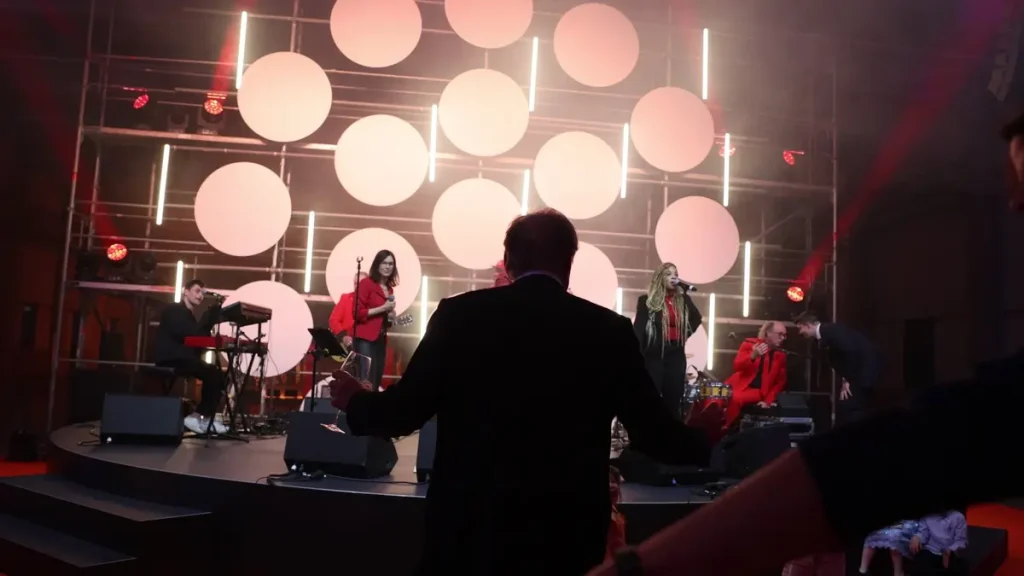 Livemusik-Band spielt vor kreisförmiger Lichtinstallation auf der Bühne bei der VEROPE-Jubiläumsfeier.