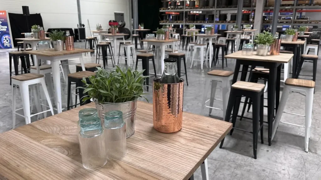 Stehtische mit Dekoration und Grünpflanzen in der Eventhalle, vorbereitet von Concept Marketing für die VEROPE-Veranstaltung.