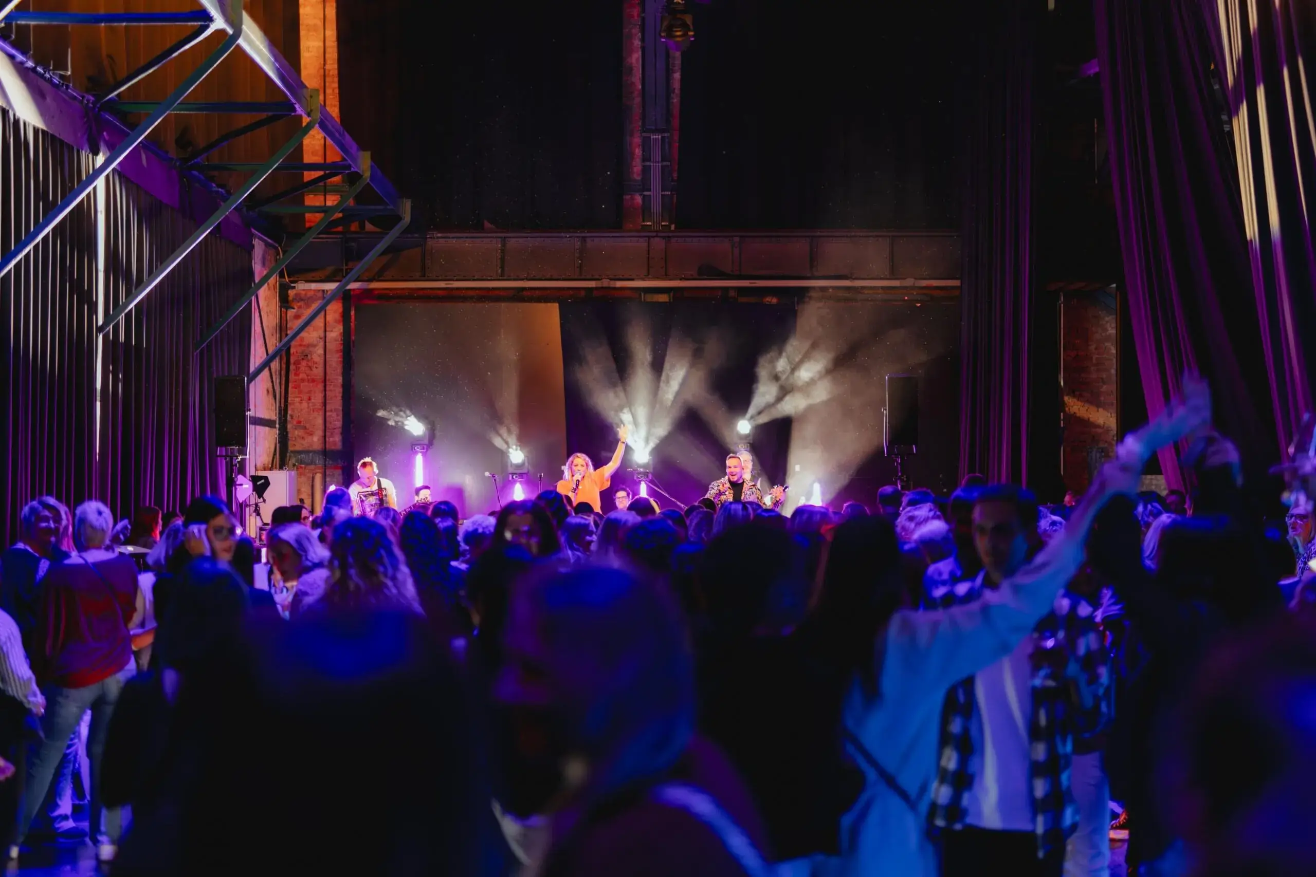 Atmosphärische Live-Show auf einer Eventbühne in einem Festsaal – professionelle Veranstaltungsplanung durch deine Eventagentur Saarland.